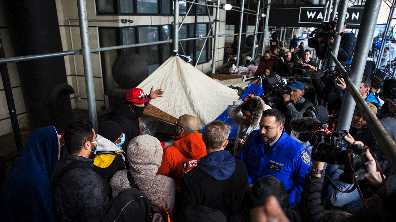 NEW YORK, NEW YORK - JANUARY 30: Migrants speak with NYC Homeless Outreach members as they camp out in front of the Watson Hotel after being evicted on January 30, 2023 in New York City. Migrants who have been staying at the Watson Hotel since arriving to NYC were evicted over the weekend to be relocated to the recently opened up migrant relief center for single adult men at the Brooklyn Cruise Terminal. The ones who refused have been camping out in front of the hotel since eviction. Several migrants who agreed to the relocation returned, complaining of lack of heat and bathroom space.