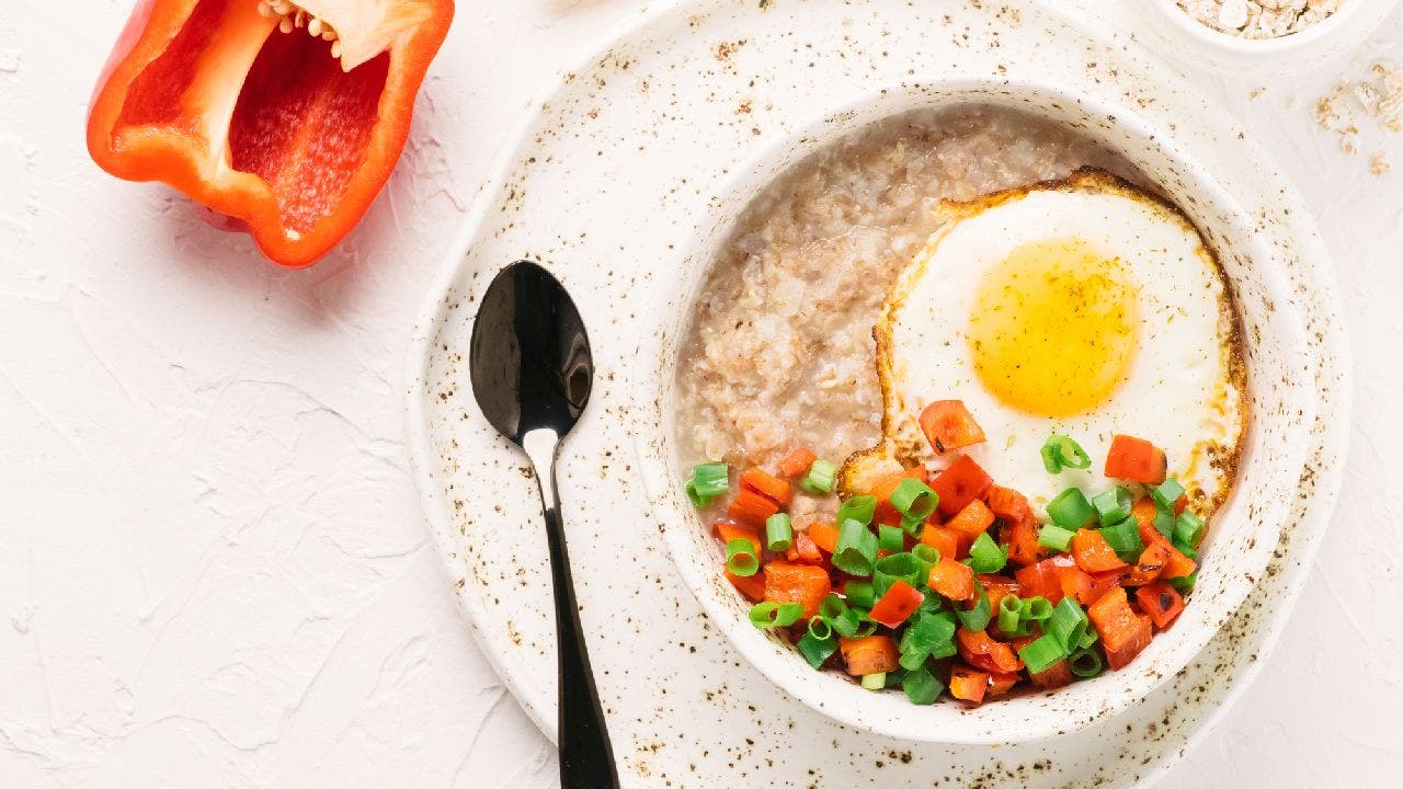 This trendy savory oatmeal bowl includes a fried egg, chopped red bell pepper and scallions. (iStock)