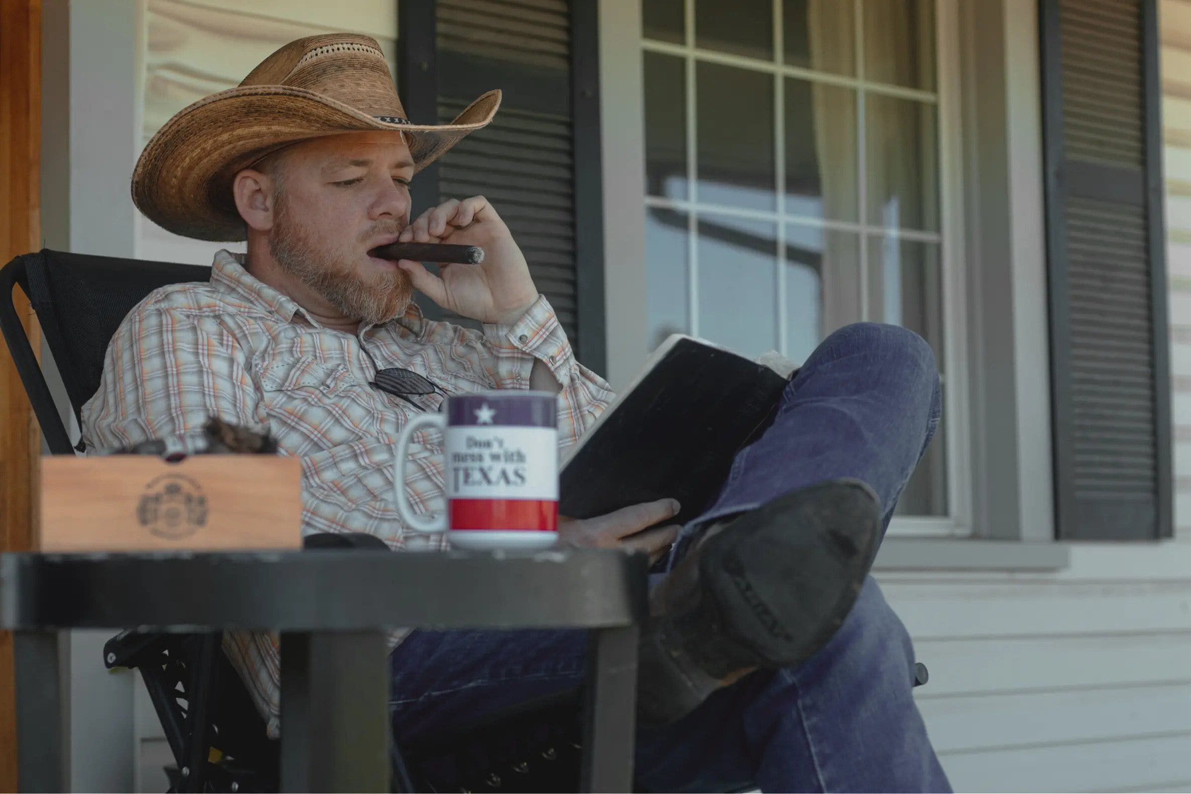 Gabriel Rench smokes cigar on front porch