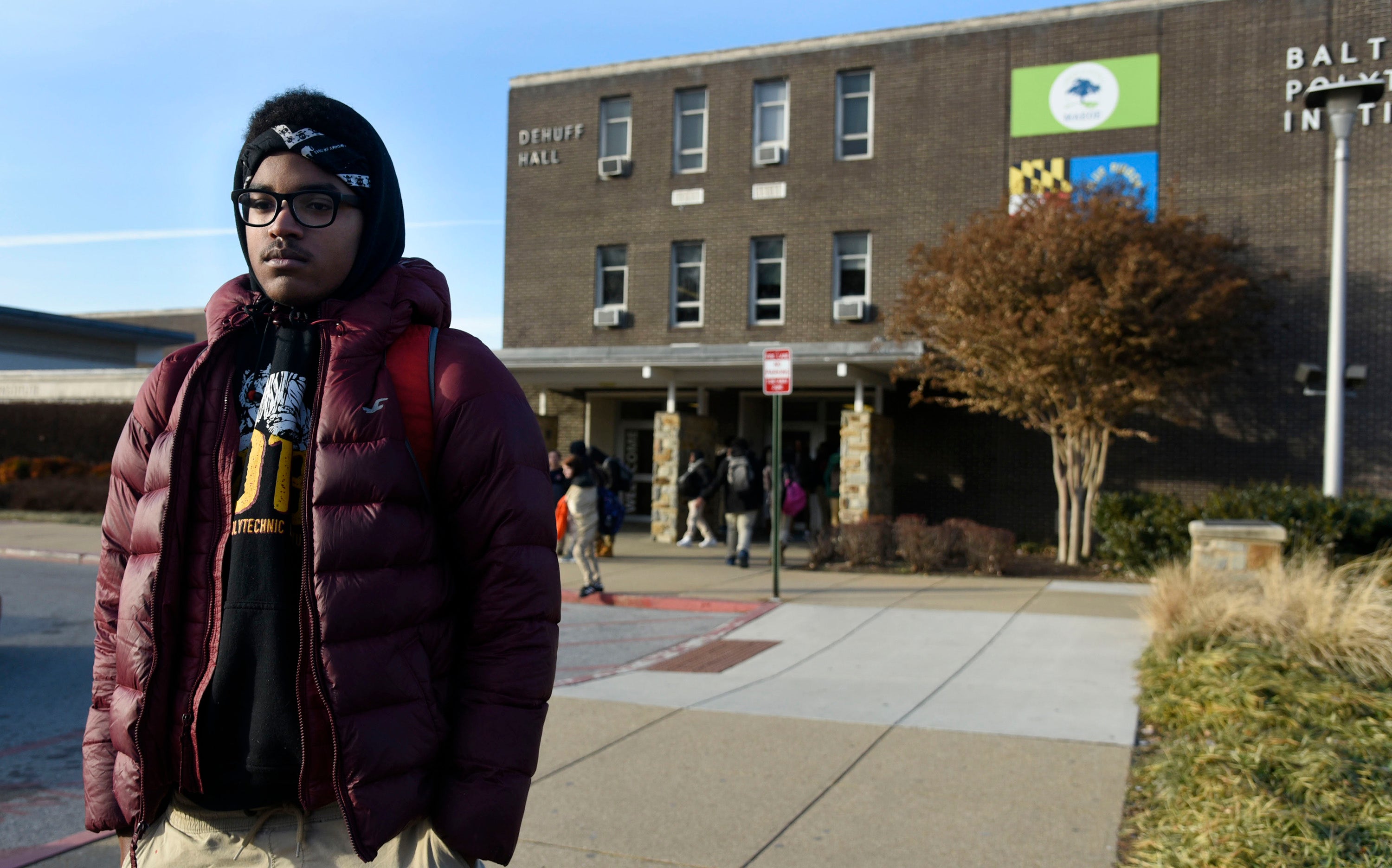 Student stands outside of a Baltimore City high school