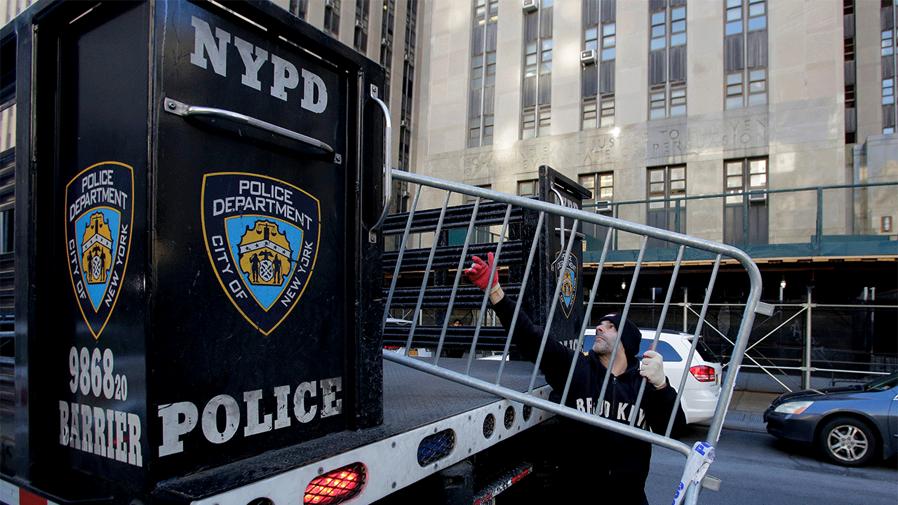 Workers with the New York Police Department set up barricades outside the Manhattan District Attorney's office after former President Donald Trump said he expects to be "arrested" on Tuesday.