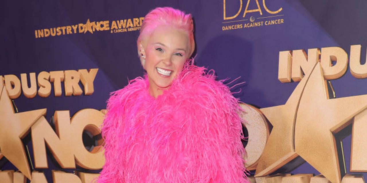 jojo siwa with pink hair and pink feather outfit on red carpet