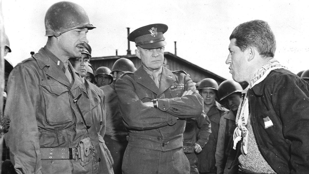 Gen. Eisenhower listens as a U.S. lieutenant questions a liberated slave laborer at the German prison camp en Ohrdruf, Germany, in April 1945. (Photo by Photo12/UIG/Getty Images)