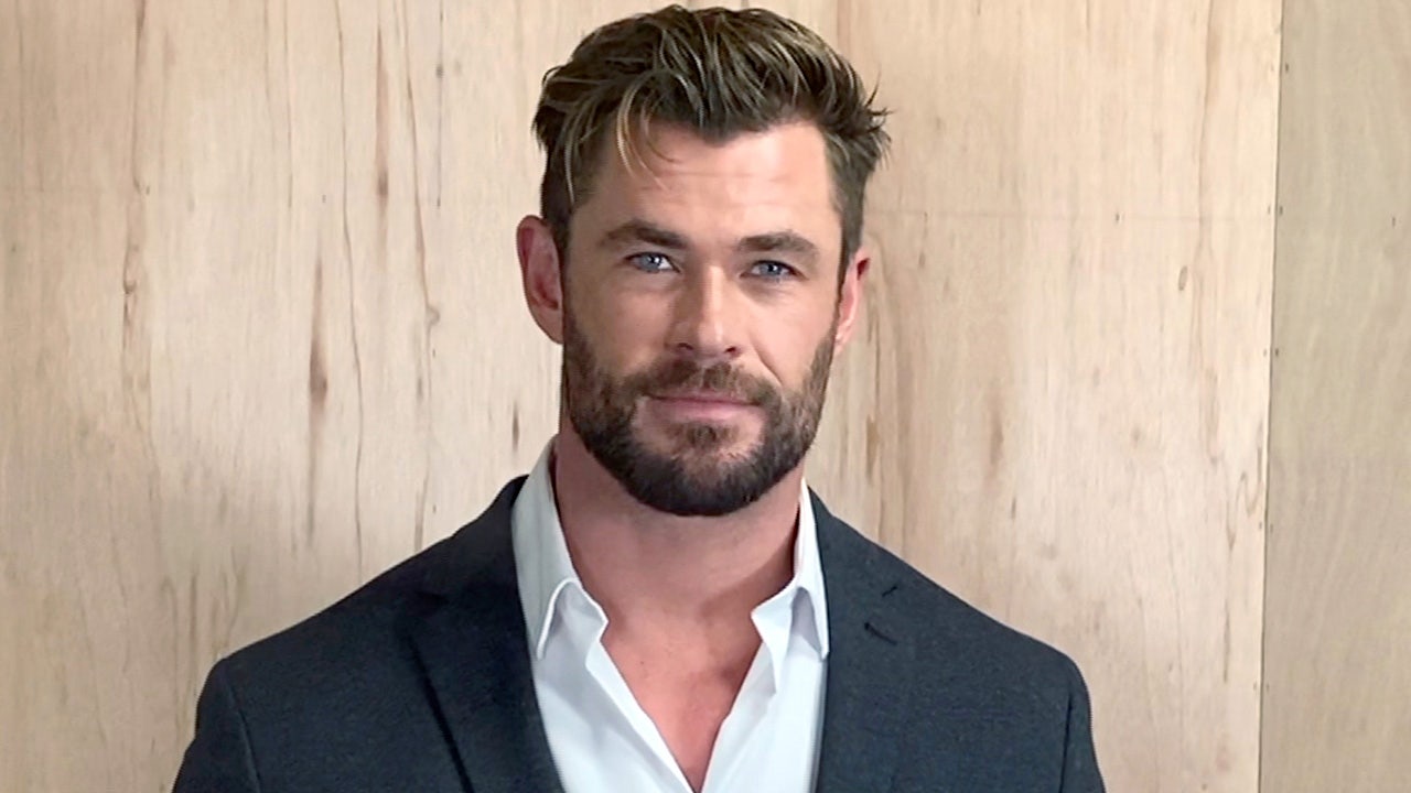 Chris Hemsworth poses for portrait session wearing suit jacket and button-down shirt