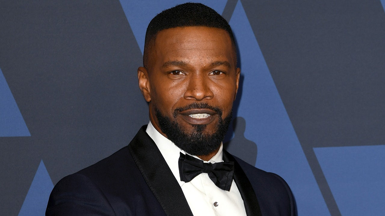 Jamie Foxx wears a suit and tie on the red carpet at a movie premiere.
