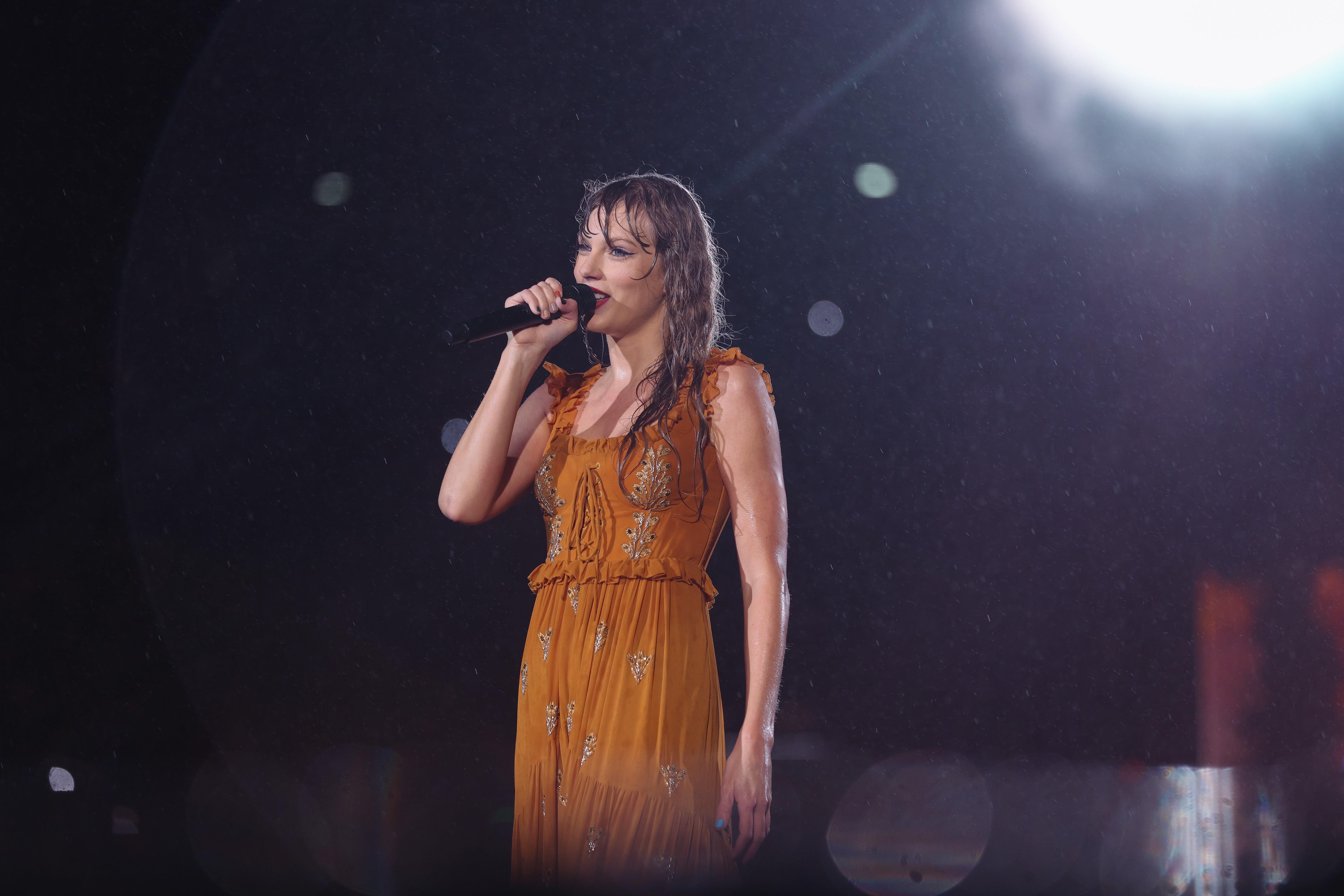 Taylor Swift singing in the rain during a concert