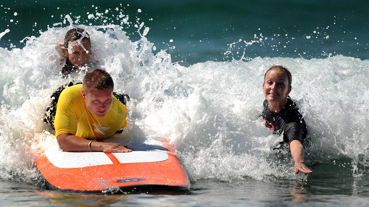 Bo Derek surving in a black suit with a man