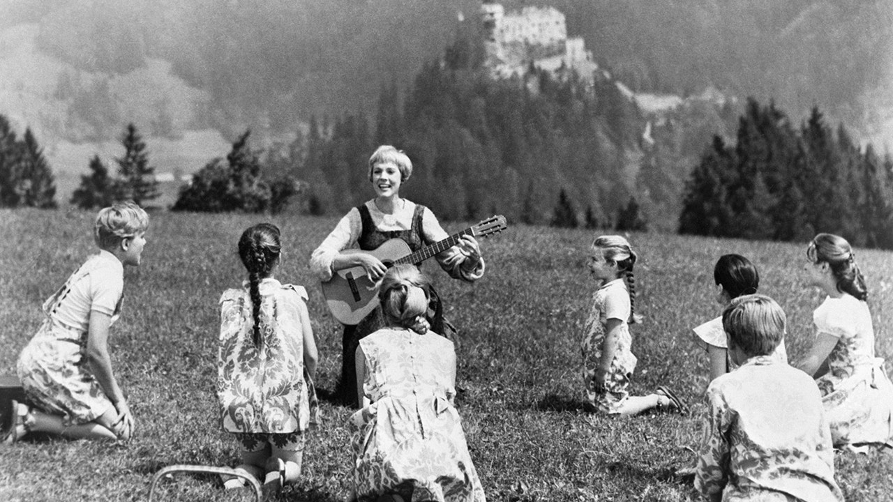 Julie Andrews playing guitar to her children castmates in The Sound of Music