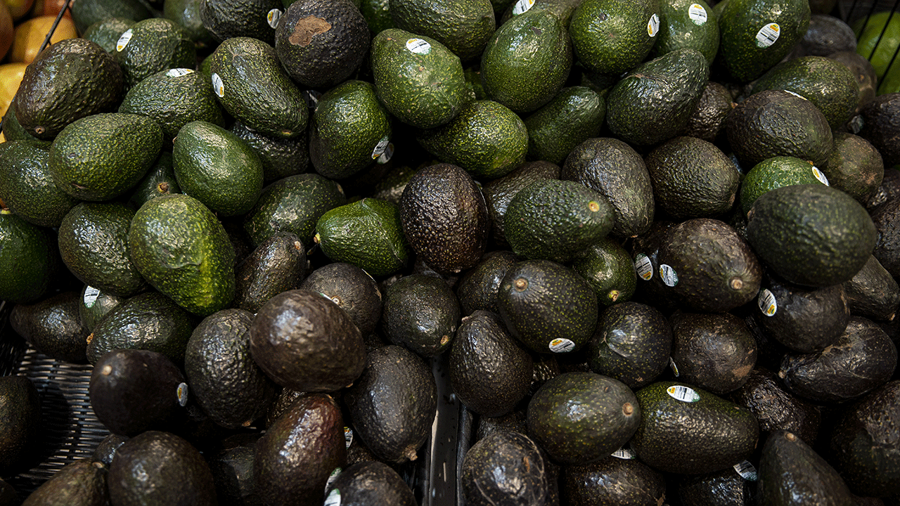 A pile of avocados in a store