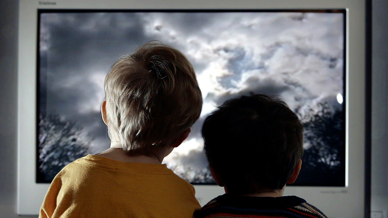 two kids watching tv