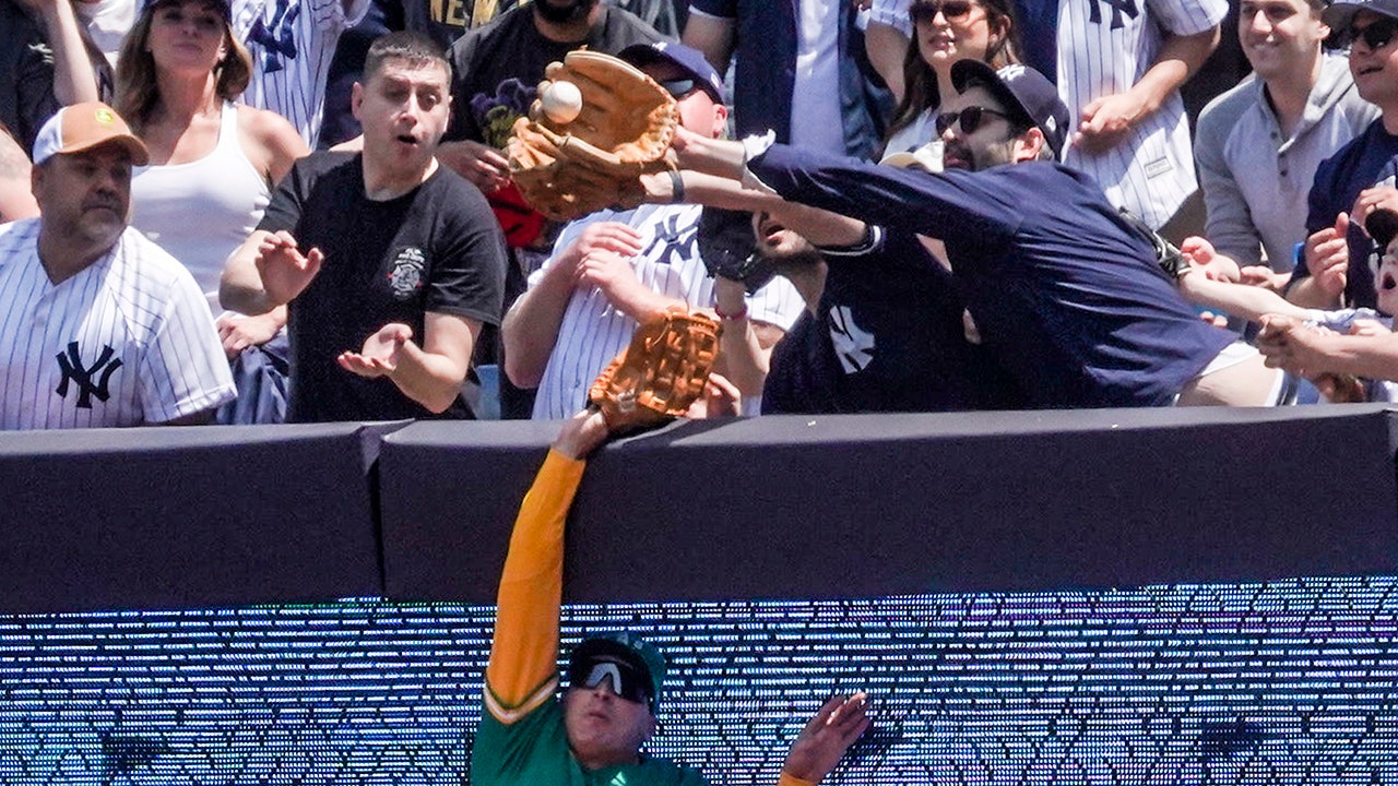 Yankees fan snatches fly ball from Athletics outfielder; umpires