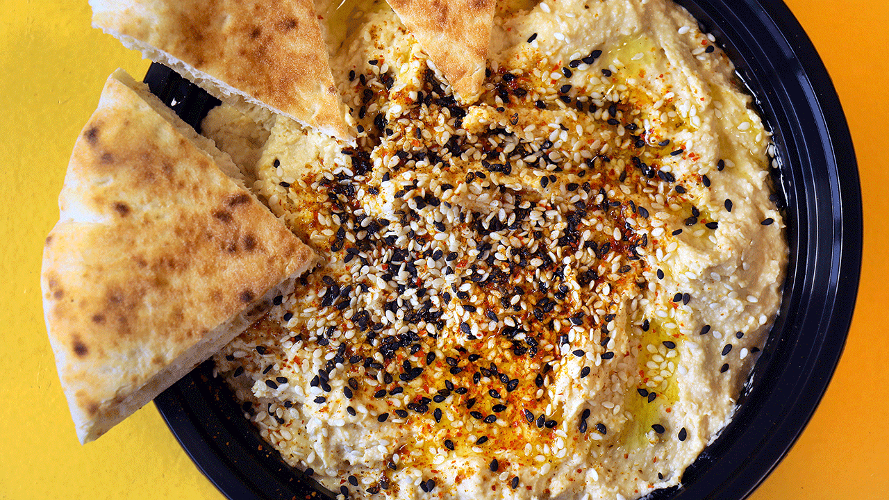 A bowl of hummus with pita bread