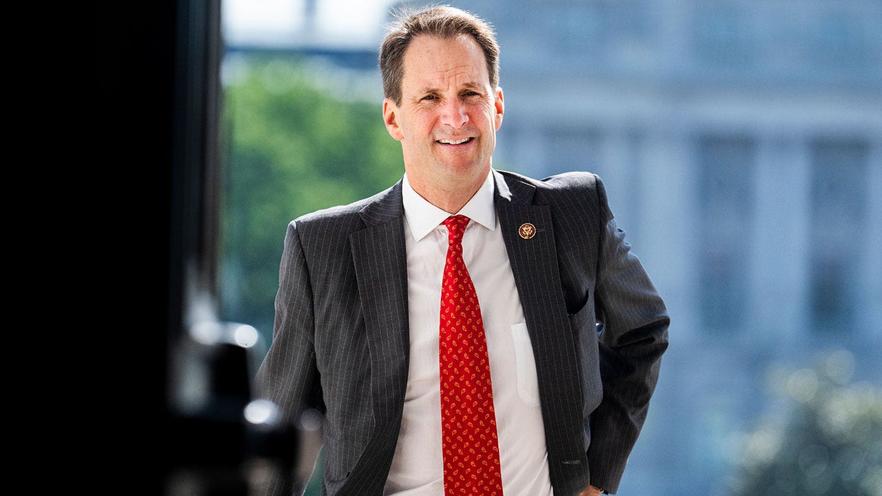 Rep. JIm Himes walks into the Capitol Building wearing a suit and red tie