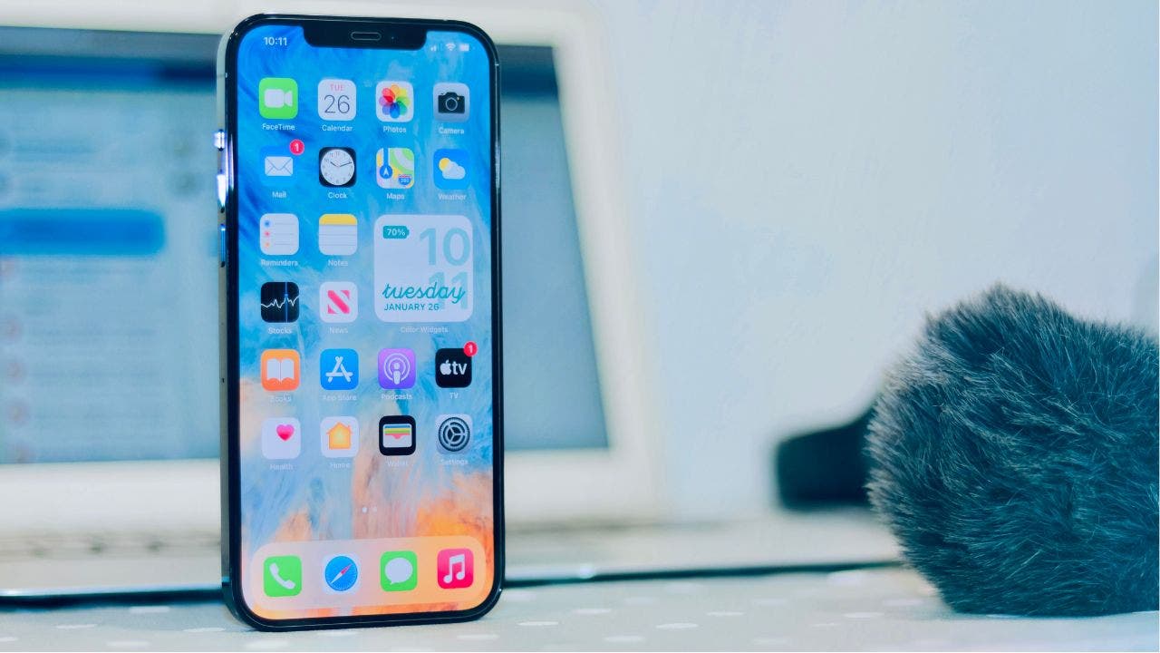 iPhone with blue background, next to computer