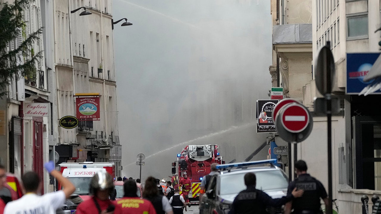Camiones de bomberos y bomberos en París luchando contra el incendio