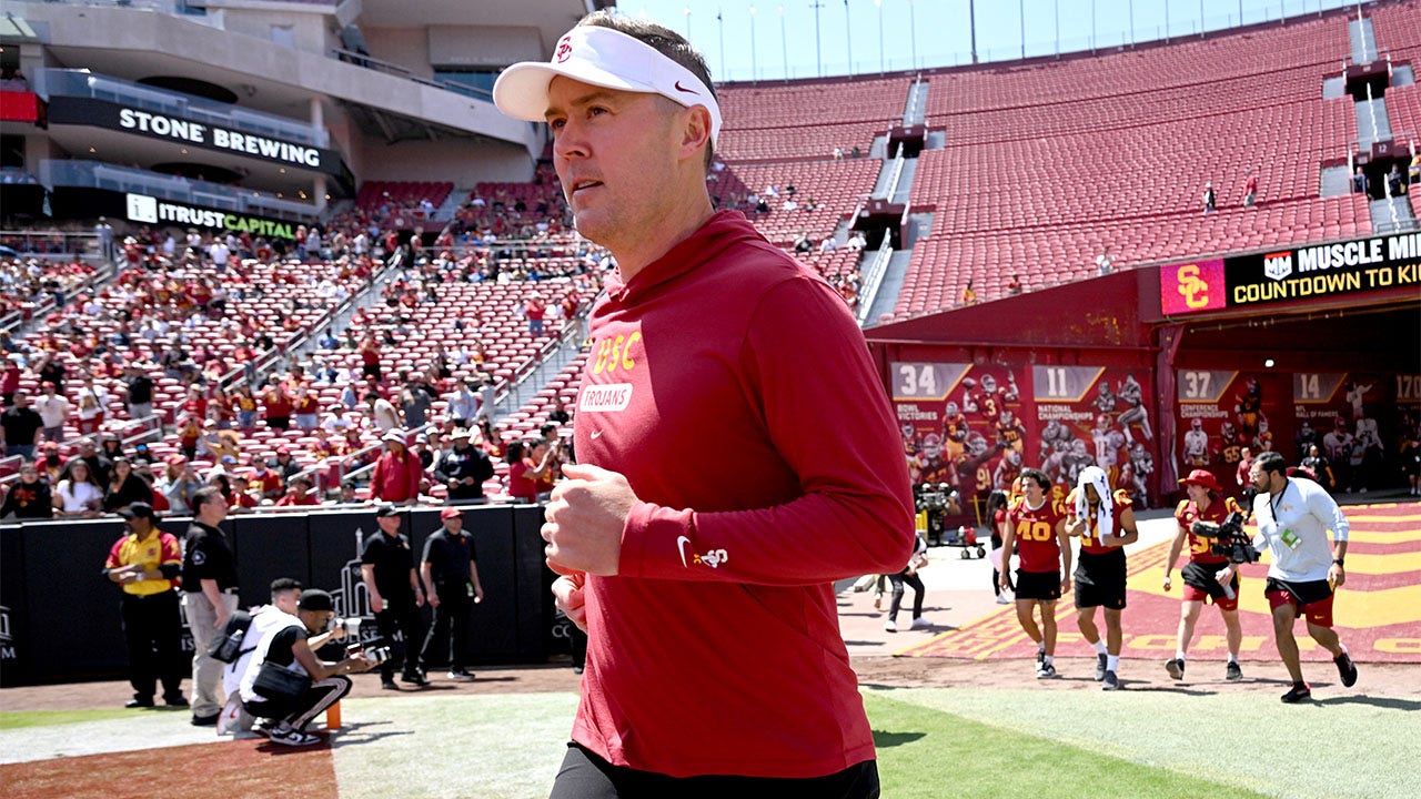 Lincoln Riley runs onto the field for USC's spring game