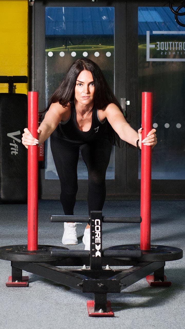 Fit personal trainer works out in a gym