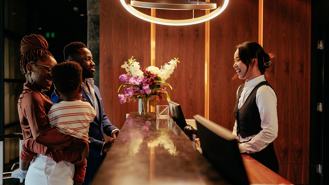 clerk smiles at a family at a hotel