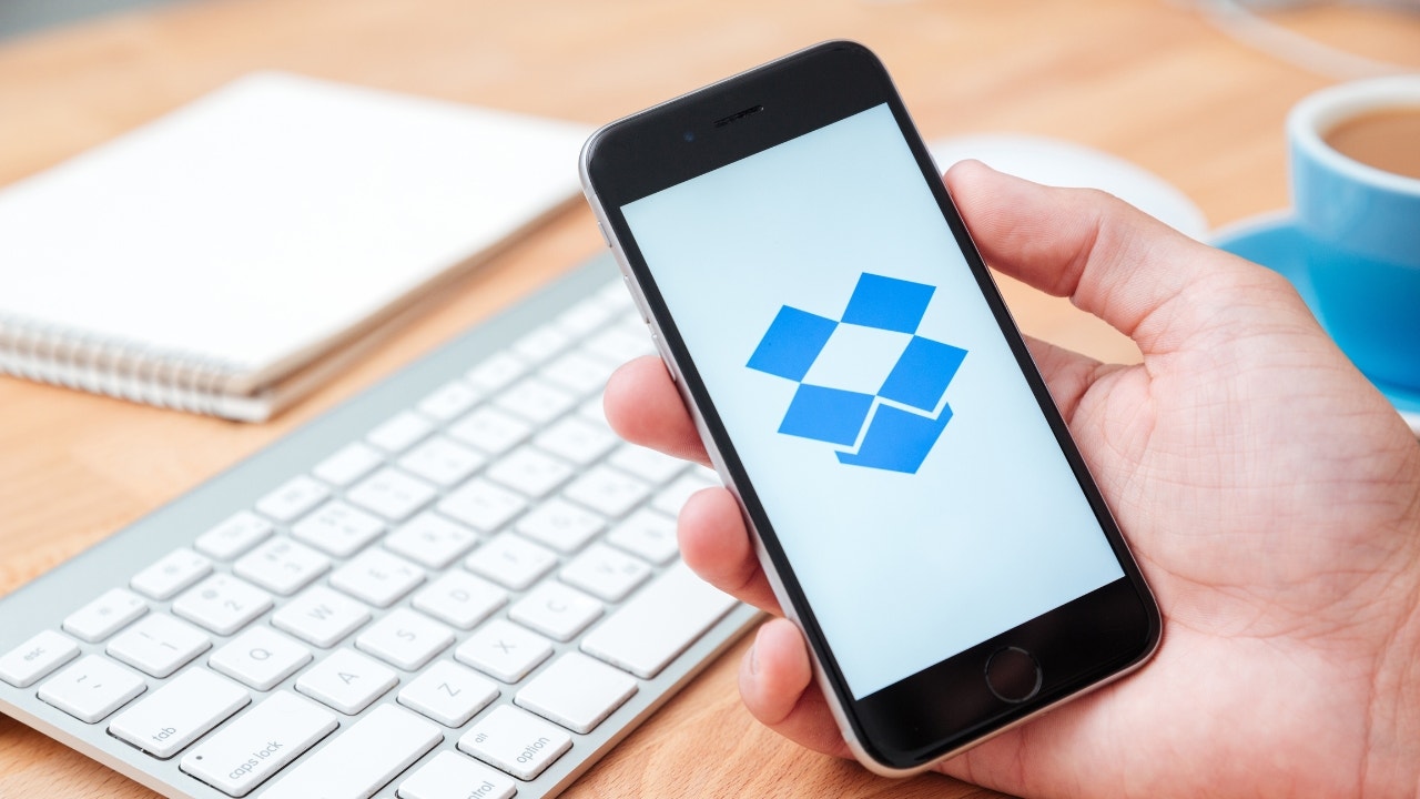 Person hält ihr Telefon hoch, während die Dropbox-App geöffnet ist.