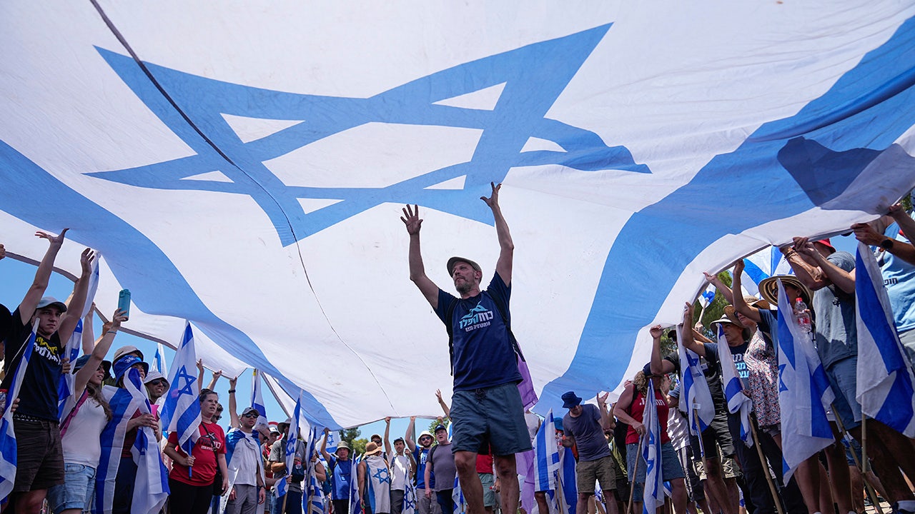 Große israelische Flagge über einer Gruppe von Demonstranten