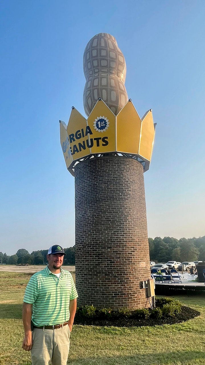 Man standing in front of giant peanut