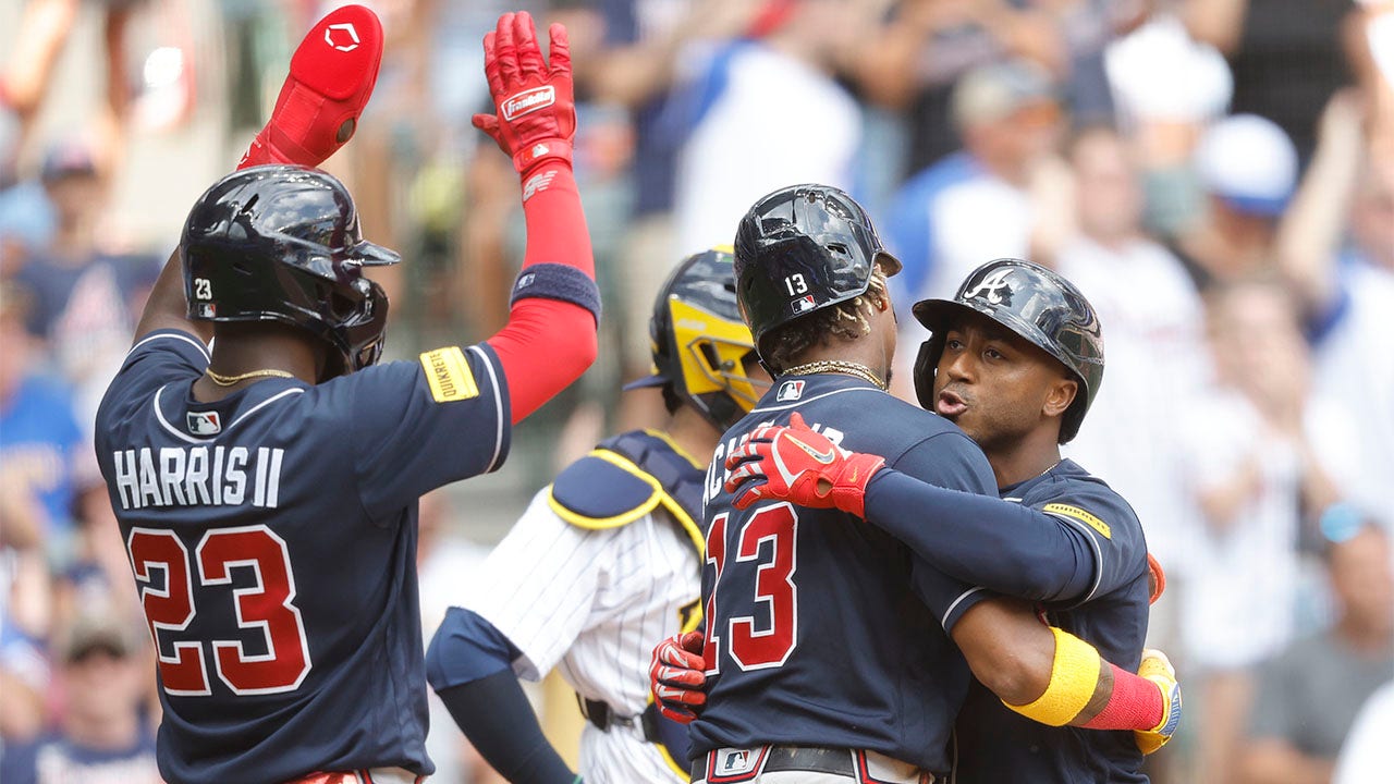 Ozzie Albies hugs Ronald Acuna Jr.