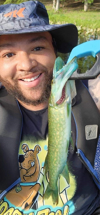A smiling John Byrd holds up his blue-mouth chain pickerel trophy.