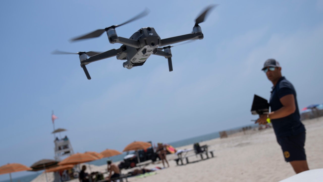 A lifeguard operates a drone