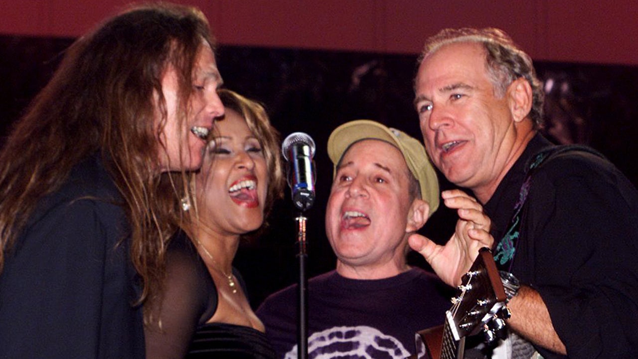 Timothy B. Schmit performing on stage with Jimmy Buffett