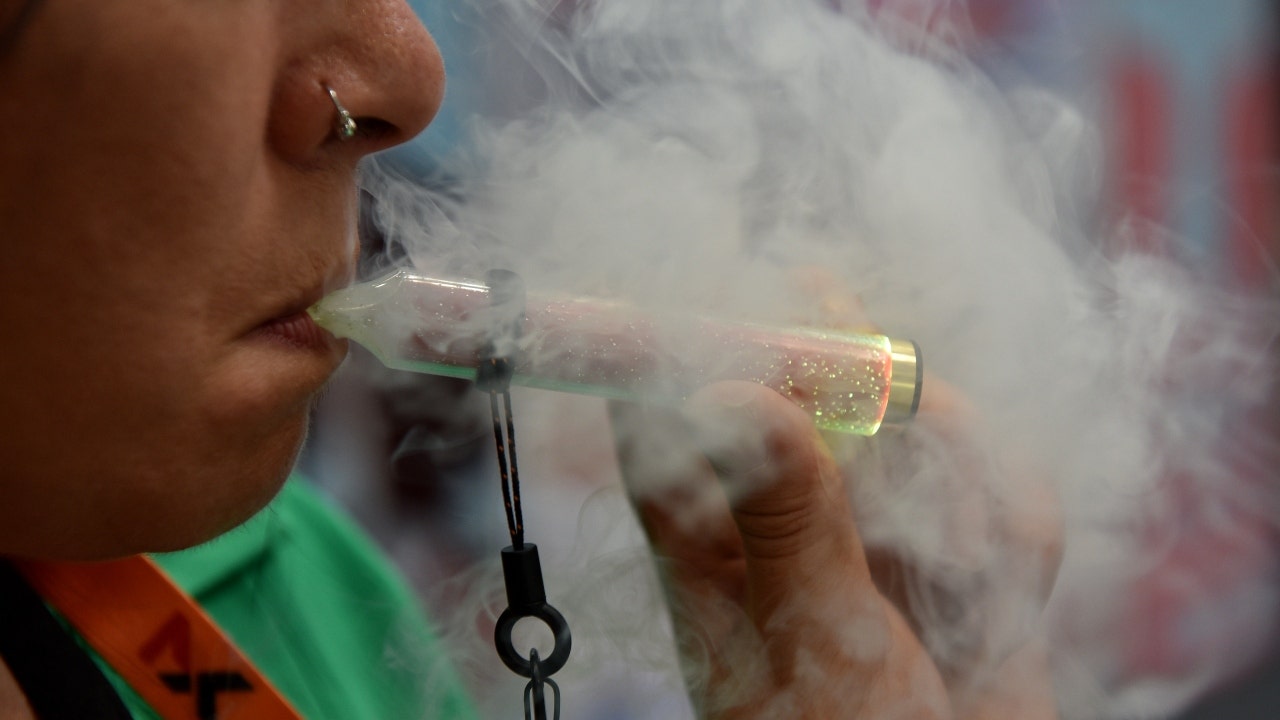 An exhibitor vapes on a McKesse light up/glowing disposable vape, e-cigarette during the Vaper Expo at National Exhibition Centre on October 07, 2022