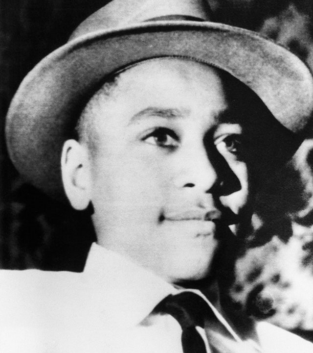Emmett Till wears a hat and a button-down shirt and tie in a photo before his murder.