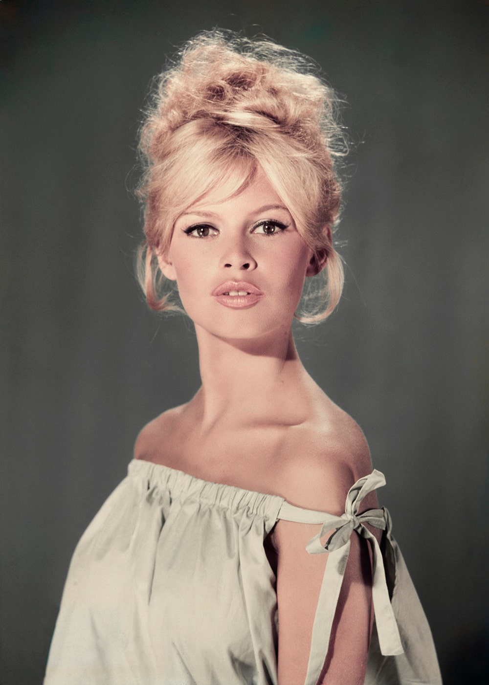 A portrait of Brigitte Bardot wearing a light hue dress in 1960