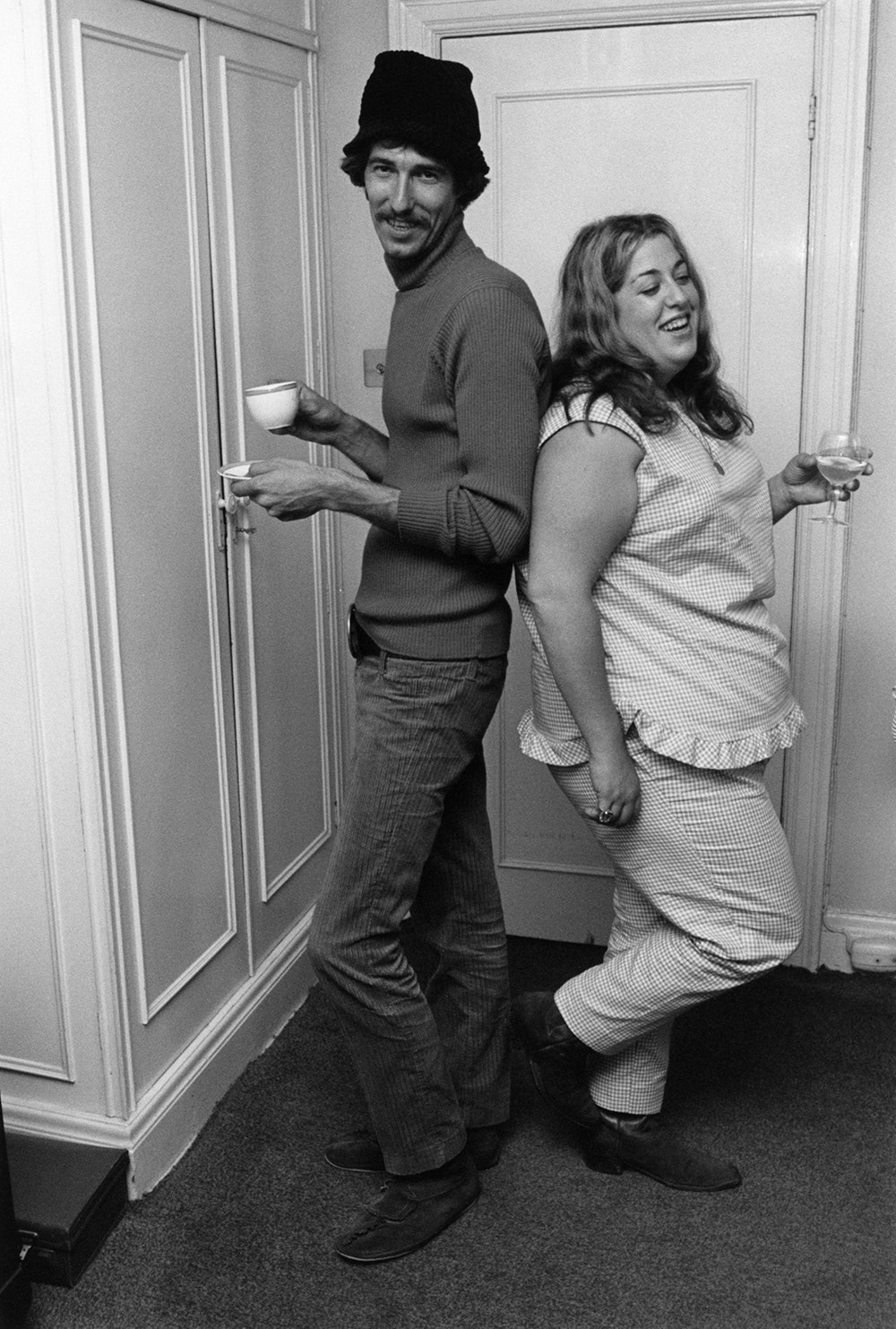 John Phillips and Cass Elliot posing with their backs against each other