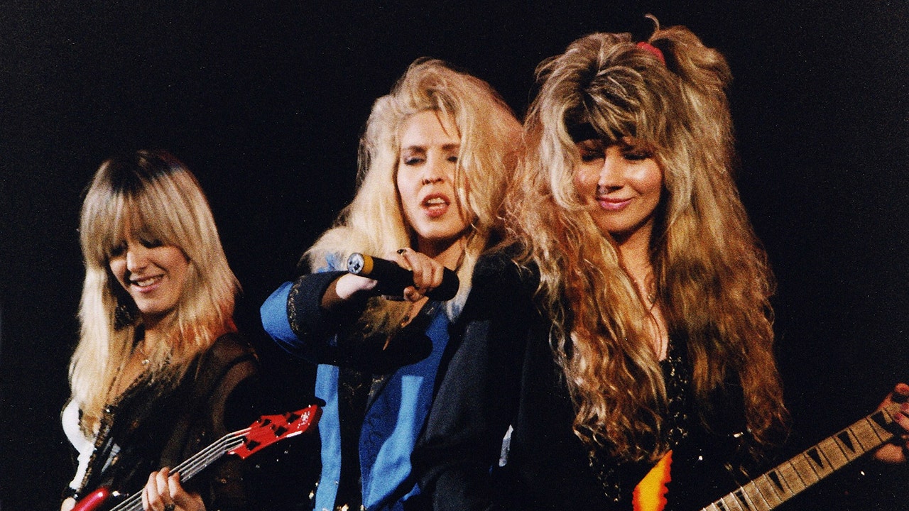 The band Vixen huddled together and performing in 1991