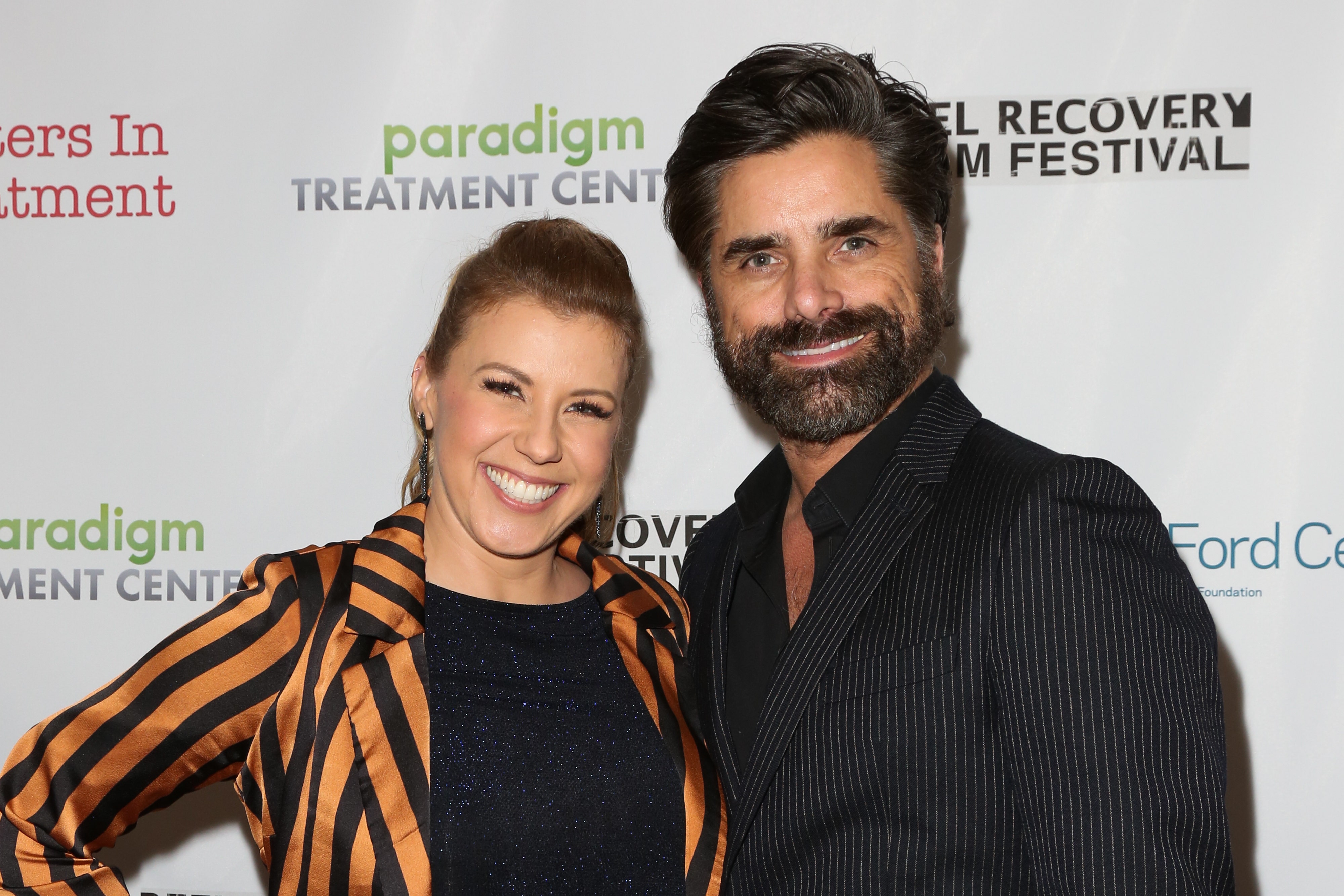 Jodie Sweetin smiling and posing with John Stamos