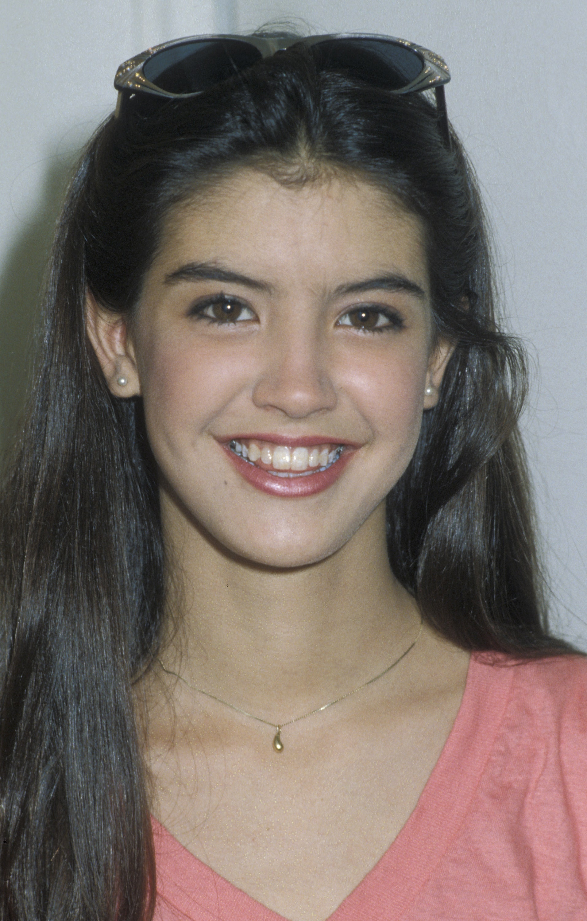 Phoebe Cates smiling with sunglasses on her head