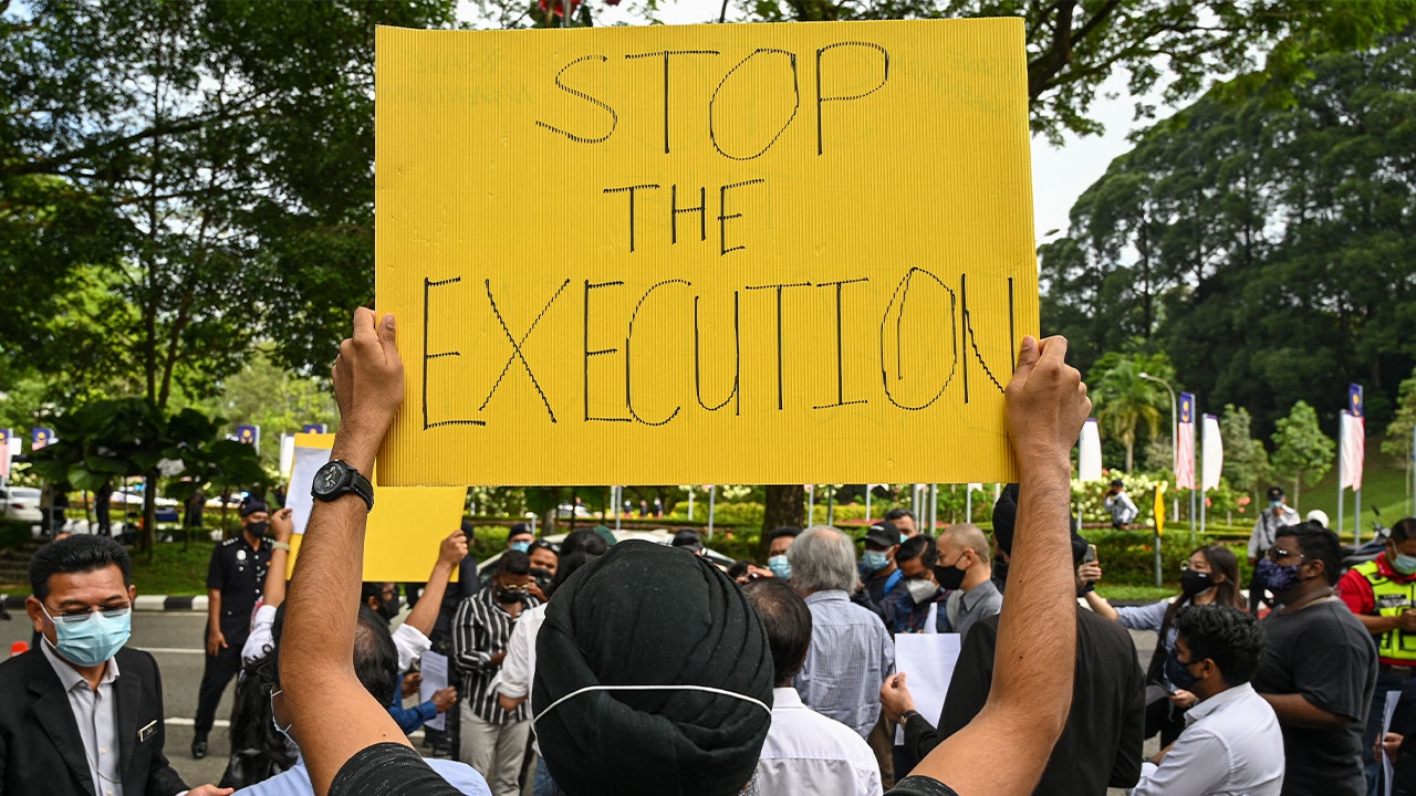Man holds sign saying 'stop the execution'