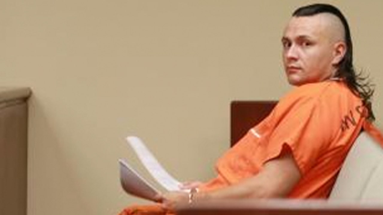 Snake Burglar Christopher jackson in orange jail uniform holding papers on courtroom bench