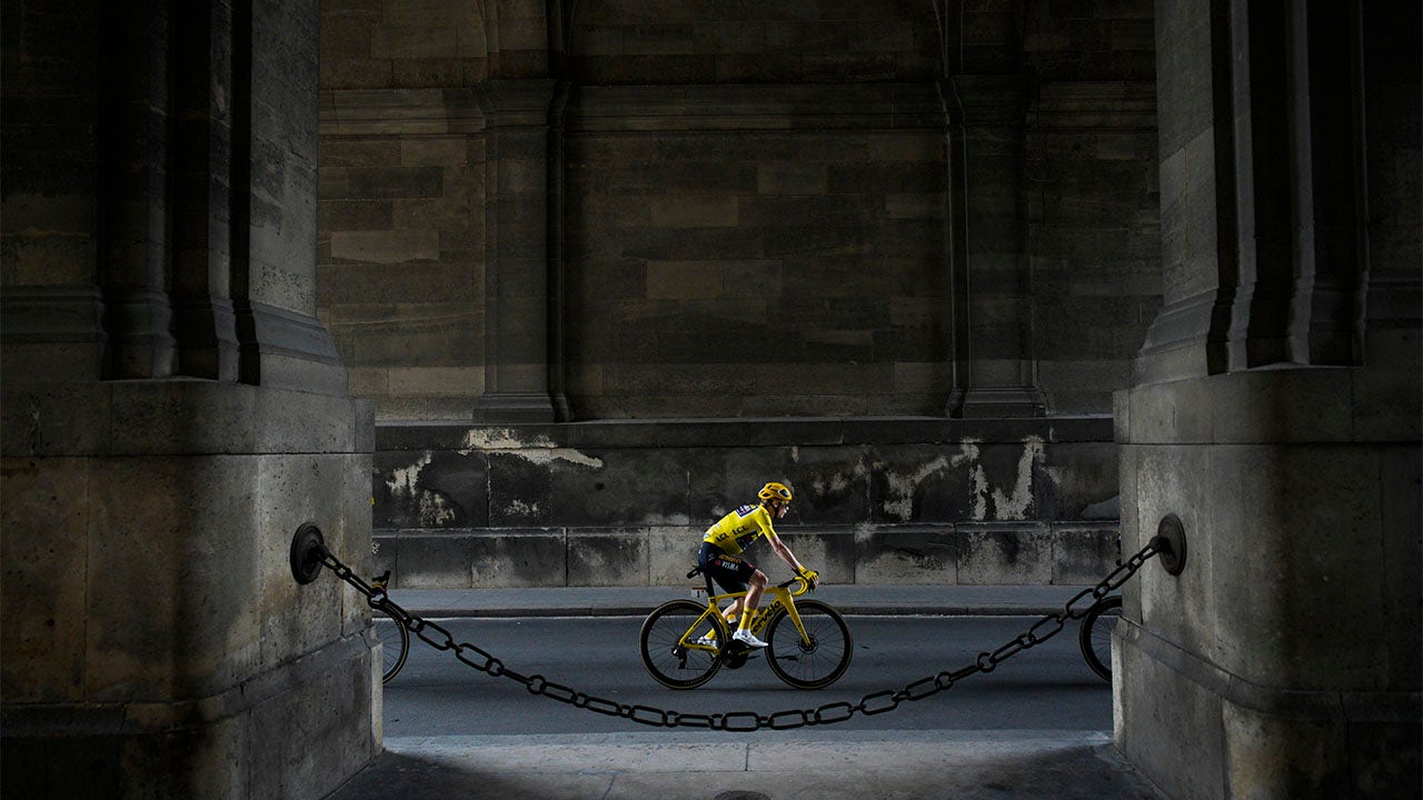 Jonas Vingegaard rides under arches