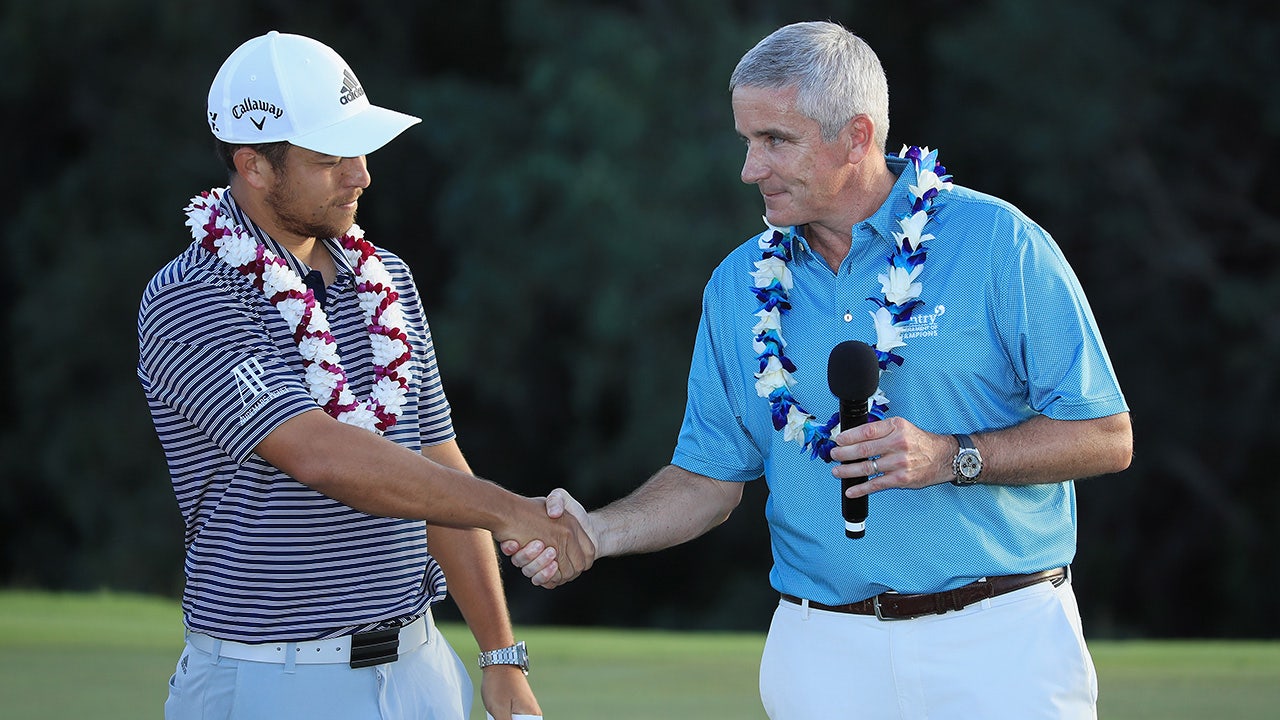 Xander Schauffele shakes hand with PGA Tour Commissioner