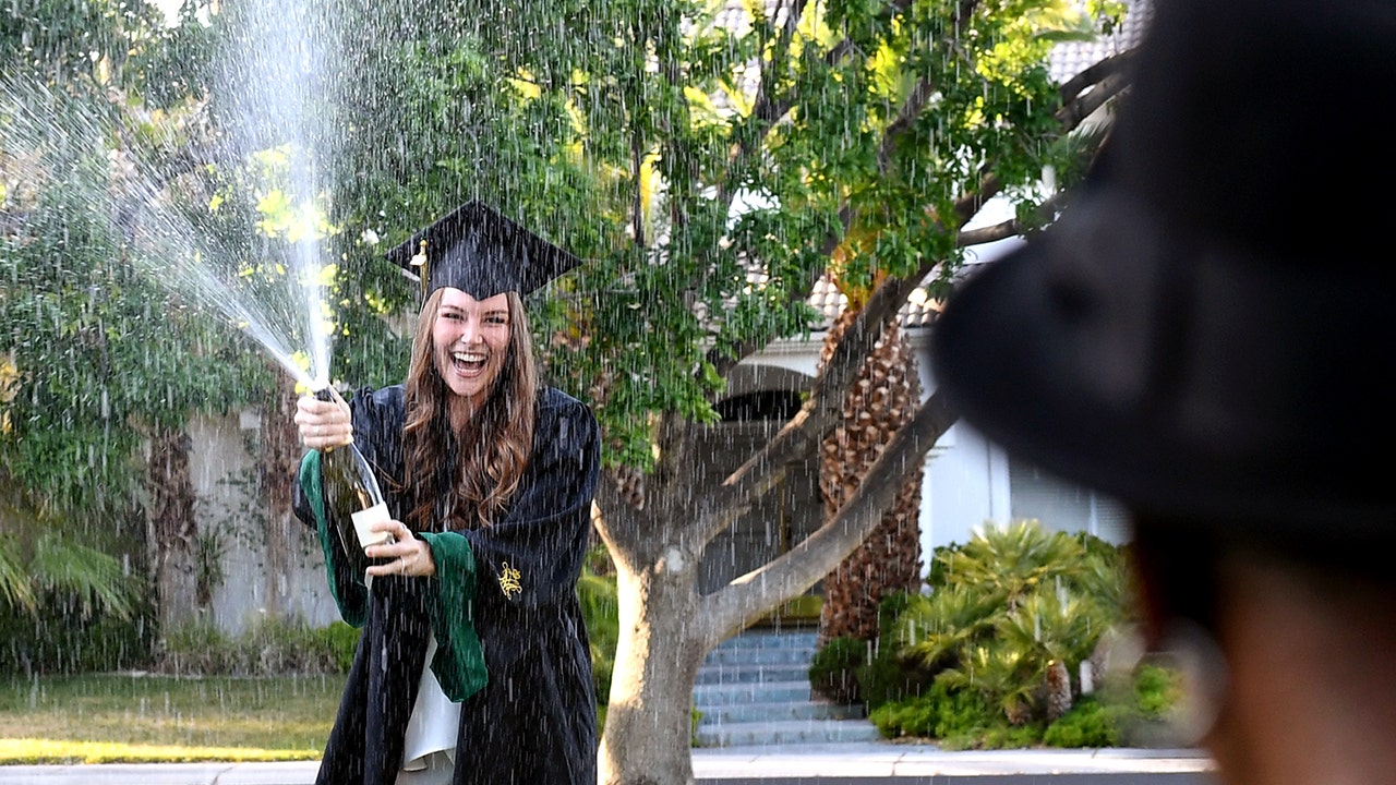 A college graduate spraying champagne