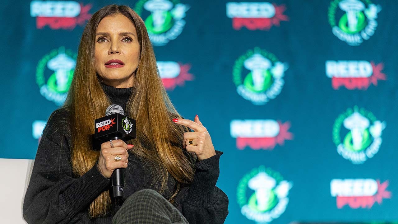 Charisma Carpenter holds a microphone on stage in Seattle 