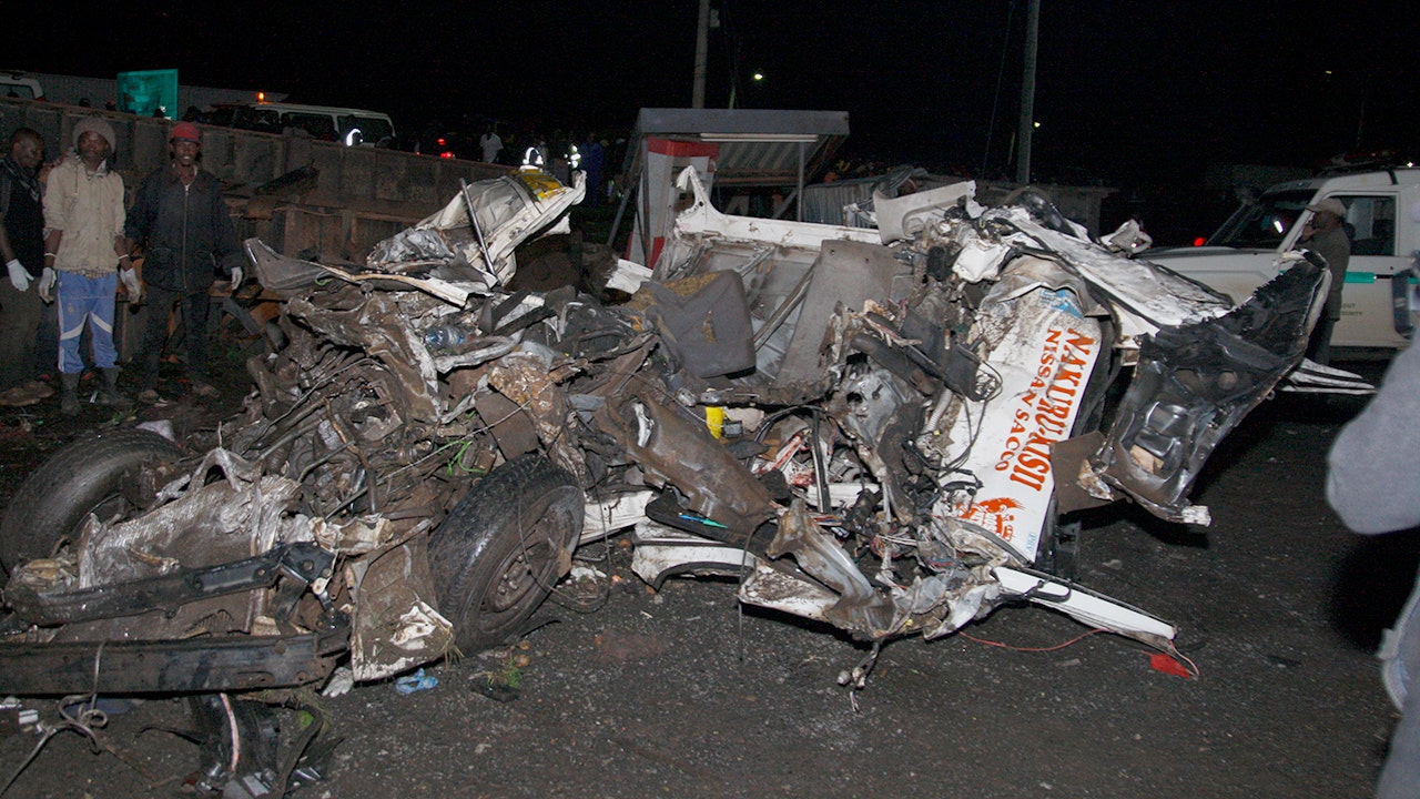 People stand around the mangled wreck of vehicles in Londiani, Kenya