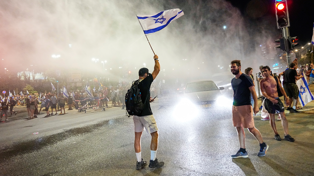 Un manifestante israelí levanta una bandera en el aire