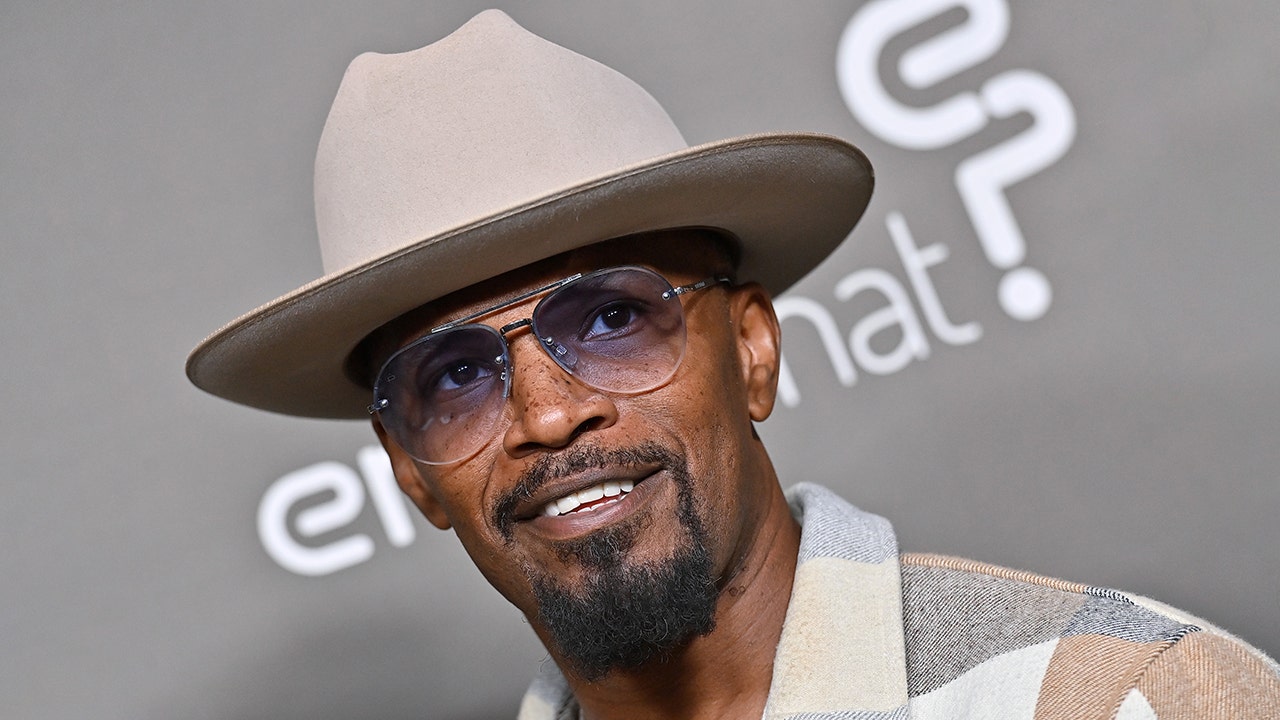 Jamie Foxx wears tan hat and coat on red carpet