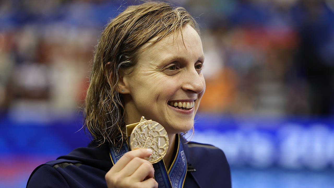 Katie Ledecky holds up her gold medal