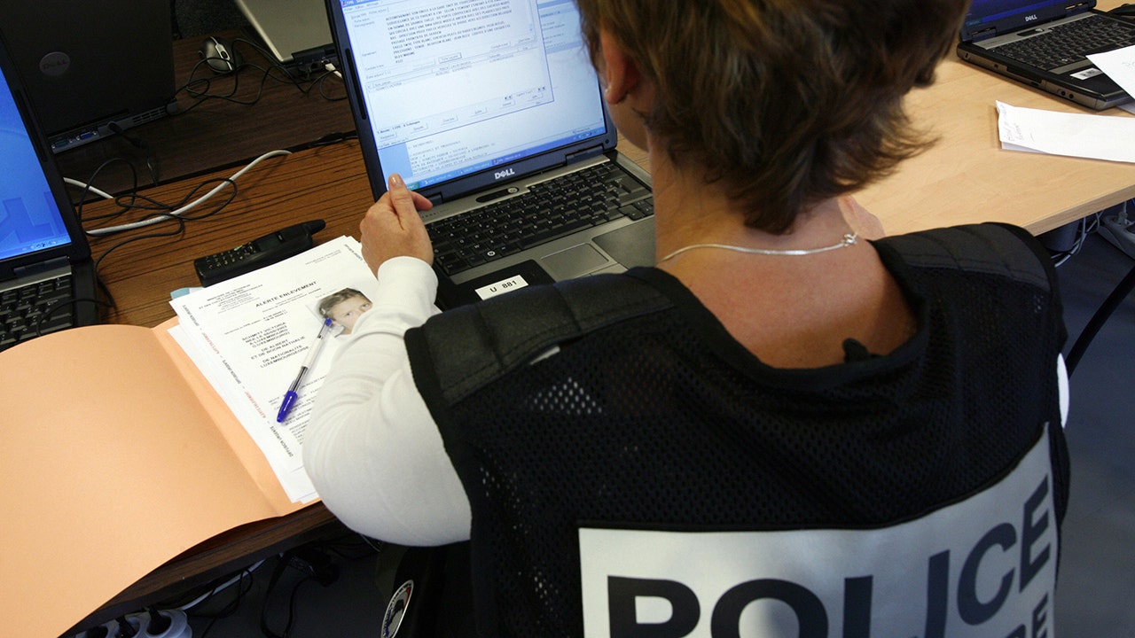 A policewoman is working on a computer.