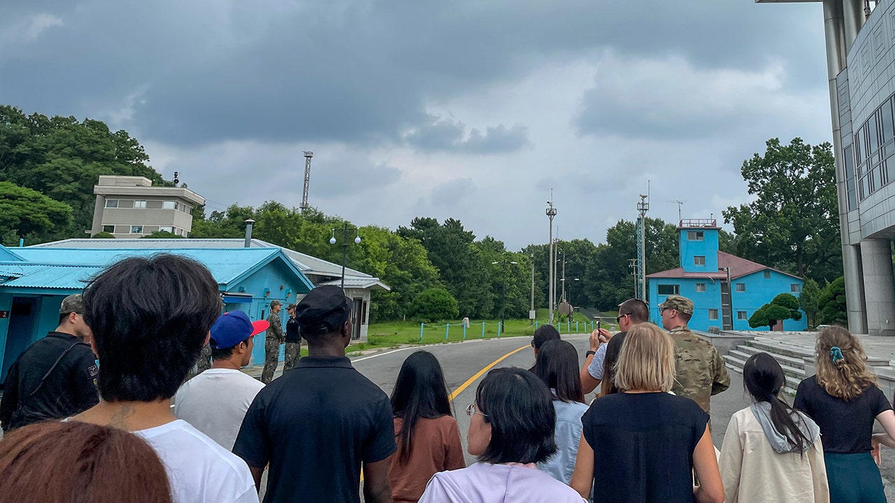 Les touristes se tiennent près d'un poste frontière à Panmunjom dans la DMZ entre la Corée du Sud et la Corée du Nord