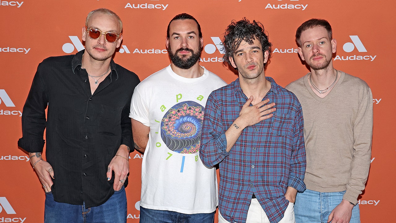 The 1975 band posing