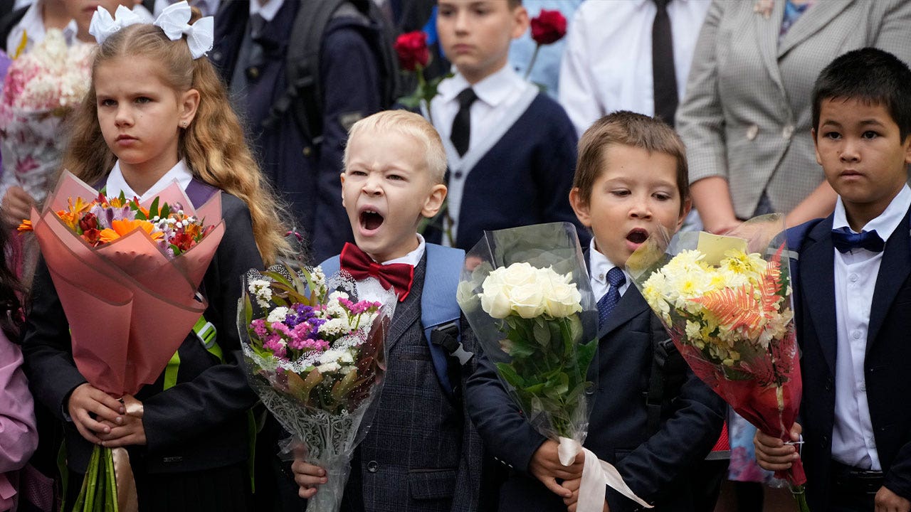 Students in Russia resume school amidst ongoing conflict in Ukraine, encountering new lessons promoting patriotism